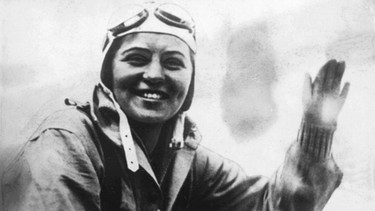 Elly Beinhorn winkt aus dem Flugzeug. Mit 25 Jahren flog die Pionierin Elly Beinhorn alleine um die Welt. Doch schon zwei Jahre zuvor wurde die Pilotin berühmt - mit einem Alleinflug nach Afrika. | Bild: picture-alliance/dpa