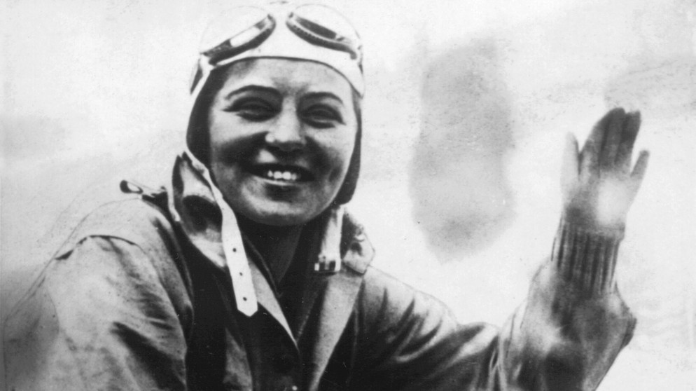 Elly Beinhorn winkt aus dem Flugzeug. Mit 25 Jahren flog die Pionierin Elly Beinhorn alleine um die Welt. Doch schon zwei Jahre zuvor wurde die Pilotin berühmt - mit einem Alleinflug nach Afrika. | Bild: picture-alliance/dpa