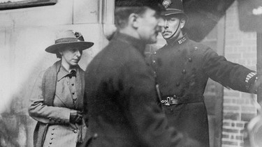 Mary Richardson verlässt 1914 das Gerichtsgebäude, sie trägt einen breitkrempigen Hut und ein helles Kostüm. Vor ihr zwei Polizisten. Die Frauenrechtlerin hat ein Gemälde in der National Gallery in London mit einem Hackbeil stark beschädigt. Weitere Porträts von bedeutenden Frauen, die die Welt veränderten, gibt's auf dem Instagram-Kanal von FrauenGeschichte und bei ardalpha.de. | Bild: picture-alliance / /HIP | Museum of London 