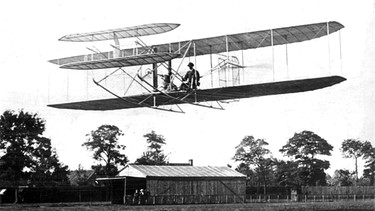 Wilbur Wright bei einem Flug bei Paris 1908. Die Brüder Orville und Wilbur Wright verband der gemeinsame Traum vom Fliegen. Anfang des 20. Jahrhunderts versuchten sie ihn wahr zu machen - und es gelang! Wir erklären euch mehr über die beiden Pioniere des Motorflugs.  | Bild: picture-alliance / dpa | dpa