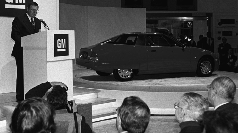 EV1 - electric passenger car - das erste Elektroauto von General Motors - hier bei der Präsentation durch Chairman John F. Smith am 4. Januar 1996 auf der Auto Show in Los Angeles. | Bild: picture-alliance/dpa/epa/Hal_Garb EV1 - electric passenger car - das erste Elektroauto von General Motors - hier bei der Präsentation durch Chairman John F. Smith am 4. Januar 1996 auf der Auto Show in Los Angeles. | Bild: picture-alliance/dpa/epa/Hal_Garb