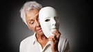 Ältere Frau hält Maske in der Hand. Der Alterungsprozess zeigt sich durch Falten und graue Haare, doch ist man deshalb schon alt?  | Bild: picture-alliance/dpa/Zoonar/Axel Bueckert