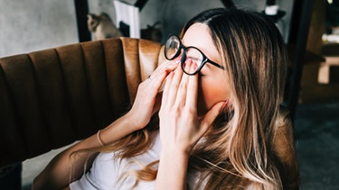 Eine junge Frau liegt erschöpft auf der Couch. Sich erholen ist wichtig. Es gibt außerdem zahlreiche Tipps, um wieder mehr Energie zu bekommen. Allerdings muss man aufpassen, dass zu viel Stress und eine zu hohe Belastung nicht in einen Burnout oder eine Depression münden. | Bild: colourbox.com
