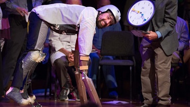 Thomas Thwaites bei der Ig-Nobelpreis-Zeremonie am 22. September 2016 an der Harvard Universität. Als Ziege verkleidet verbrachte der Londoner Designer im Jahr 2014 einige Zeit unter Ziegen in den Schweizer Bergen, um dem Mensch-Sein zu entfliehen. | Bild: dpa-Bildfunk